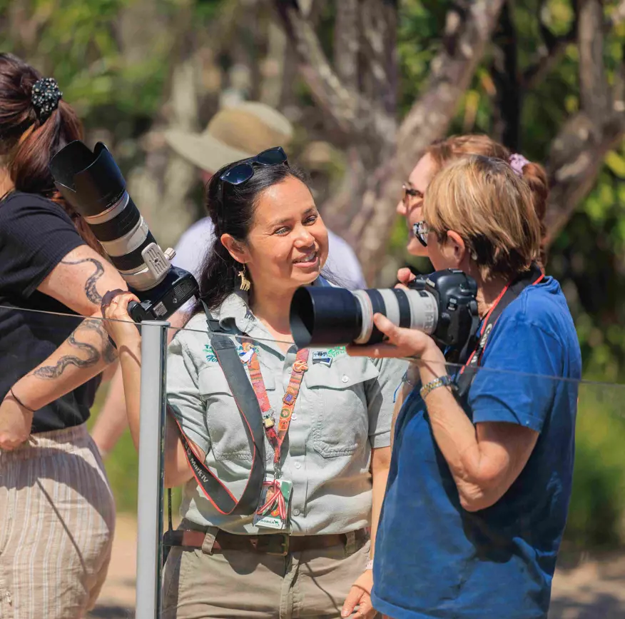 Participants learning photography skills using cameras during an outdoor workshop at the Zoo.