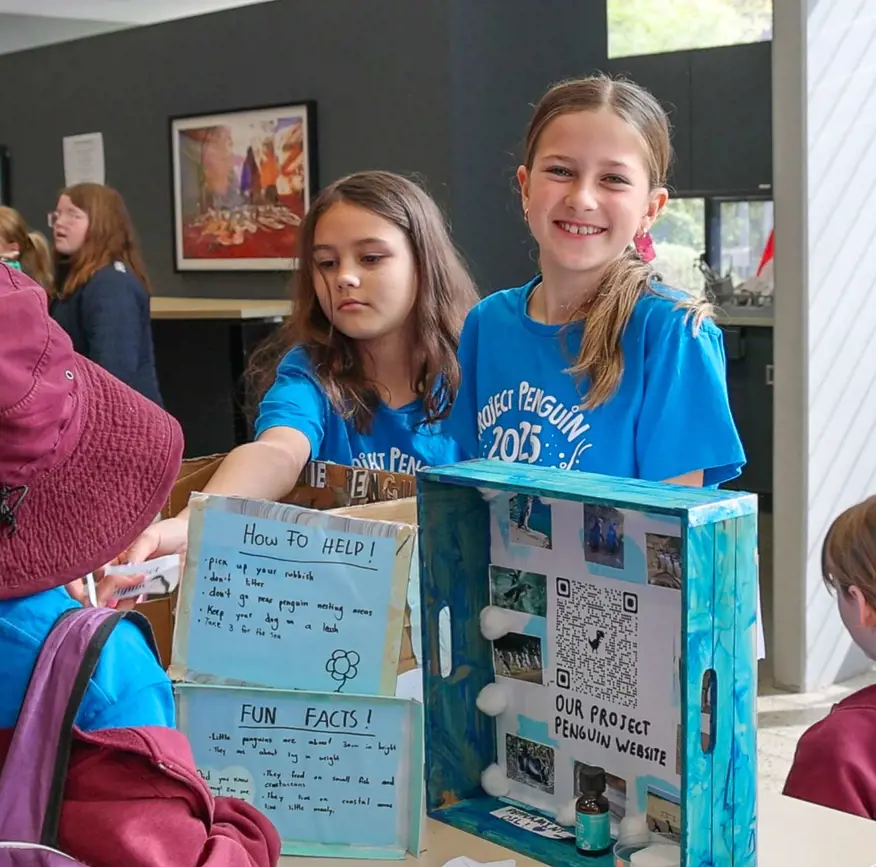 School students presenting a penguin project during an interactive education session.